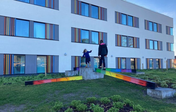 Two girls climbing on structures outside East Lothian Community Hospital