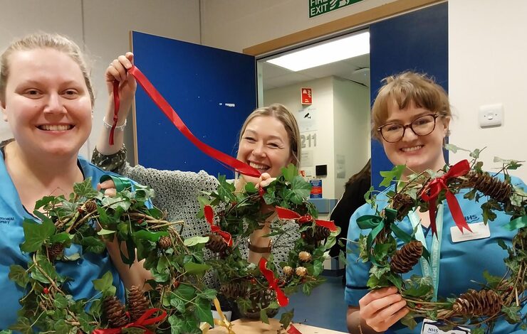 three members of NHS Lothian staff presenting their festive garlands to the camera