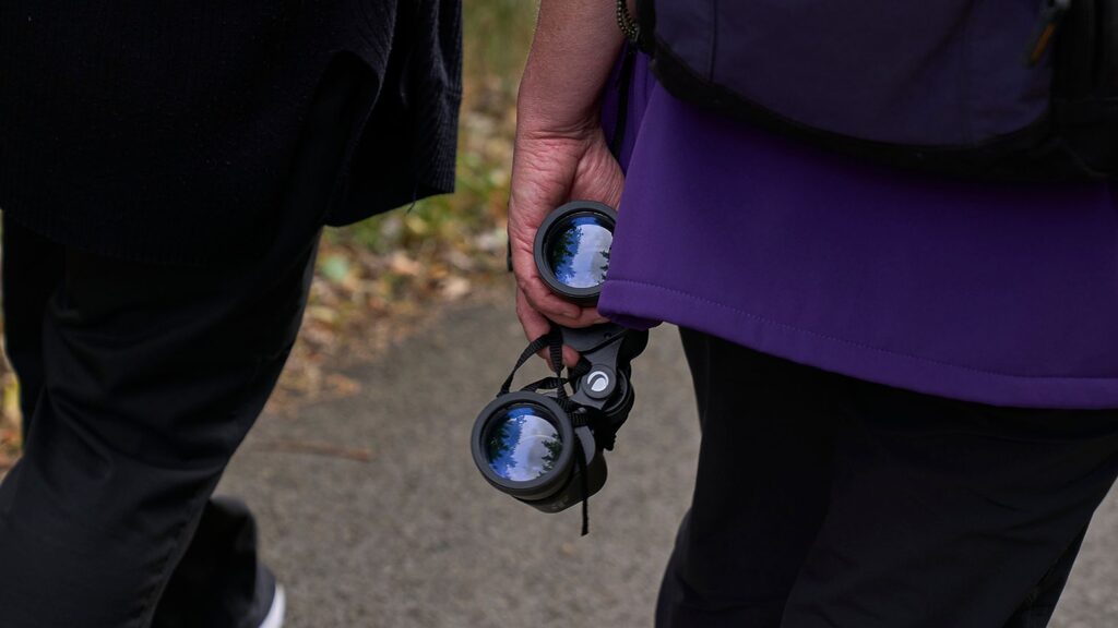 someone walking holding binoculars