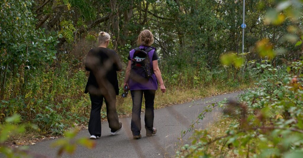 Lou walking with a staff member