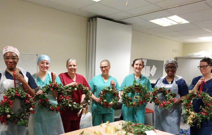 staff at the RIE holding up their festive garlands after a workshop with the Charity's Nature Ranger